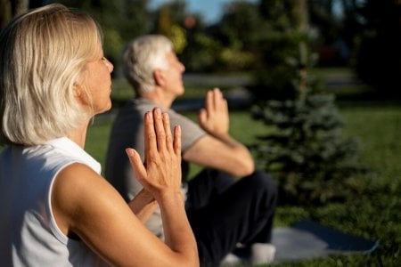 side-view-older-couple-practicing-yoga-outdoors_23-2148729836.jpg