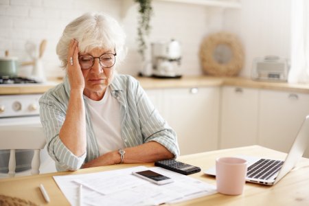 sad-frustrated-senior-woman-pensioner-having-depressed-look-holding-hand-her-face-calculating-...jpg
