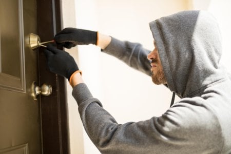 profile-view-man-with-hoodie-trying-pick-lock-house-forcing-his-entry.jpg