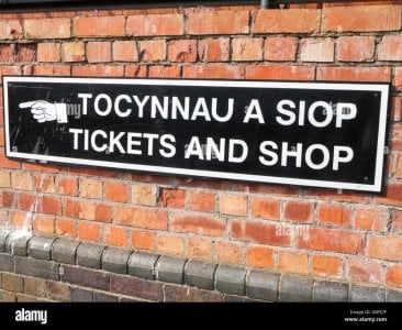 hand-sign-pointing-to-tickets-and-shop-sign-in-english-and-wales-language-GDPJ7F.jpg