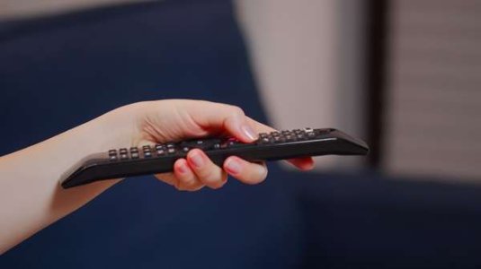 compressed-close-up-caucasian-hand-with-tv-remote-switching-channels-while-sitting-couch-youn...jpeg
