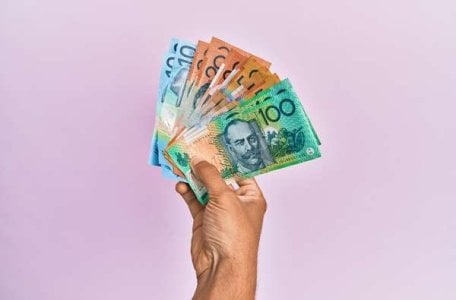 compressed-hispanic-hand-holding-australian-dollars-banknotes-isolated-pink-background.jpeg