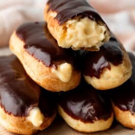 eclairs with chocolate on top and filled with pastry cream.