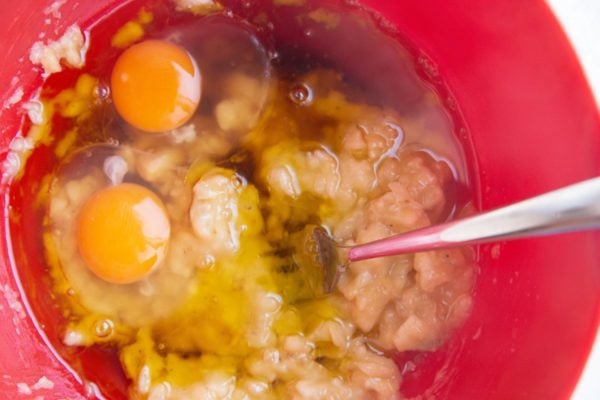 Mashed banana, eggs, pure maple syrup and vanilla extract in a large mixing bowl, ready to be mixed