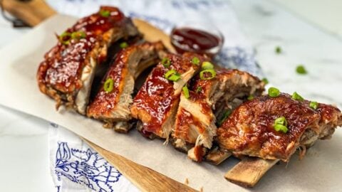 Side view of Easy Instant Pot Ribs on a Wood Cutting Board