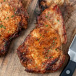 Air fryer pork chops on a wooden board.