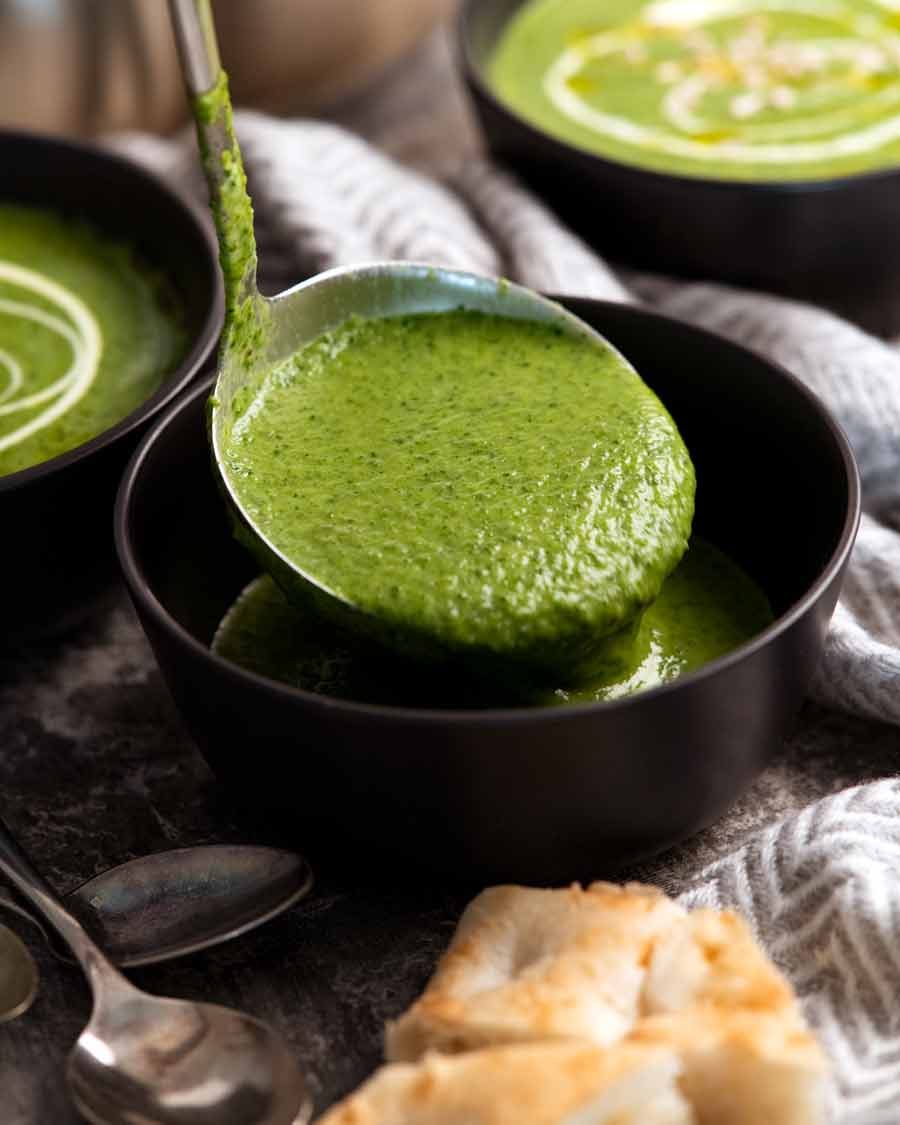 Ladling Immunity Boosting Green Goddess Soup into bowls