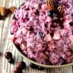 Cranberry Millionaire Salad in a bowl topped with. pecans and cranberries