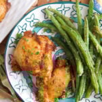 Overhead view of sweet and spicy boneless chicken thighs on plate with green beans Overhead view of sweet and spicy boneless chicken thighs on plate with green beans